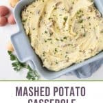 mashed potato casserole in a blue square dish surrounded by mini potatoes and parsley.