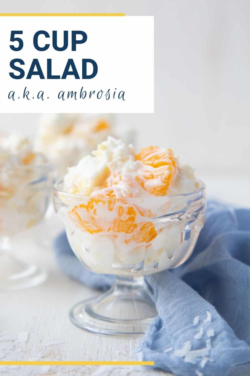 glass parfait dish with ambrosia in it, sitting on a blue towel.