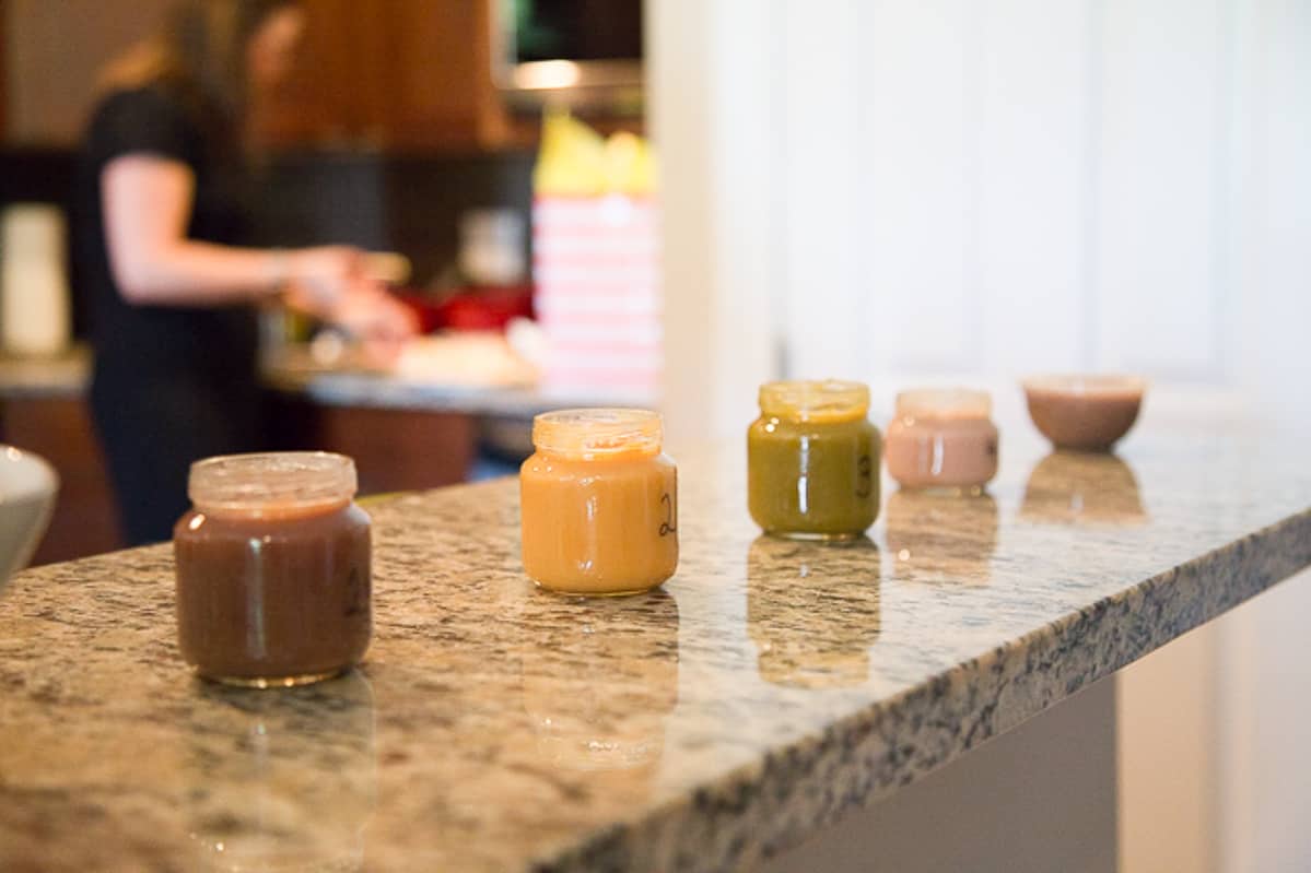 baby food jars lined up on a marble countertop.