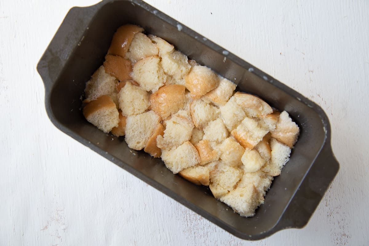 bread cubes in milk custard in a loaf pan.