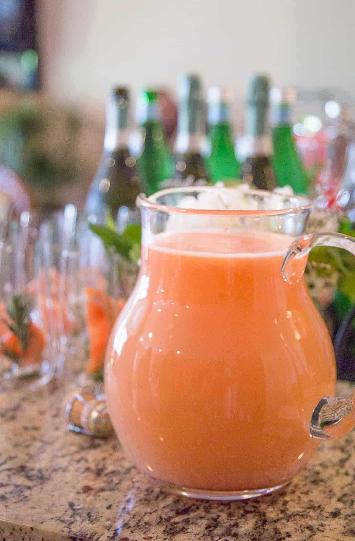 large pitcher filled with a grapefruit cocktail.