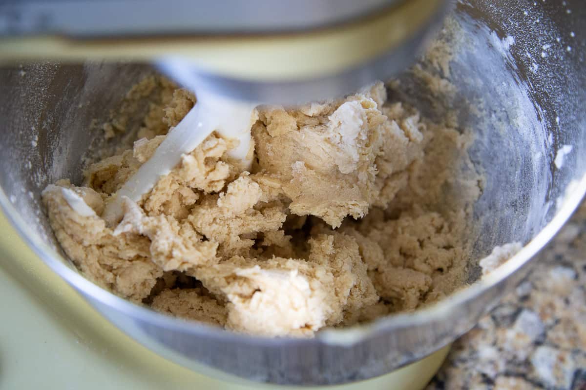 plain cookie dough in a stand mixer with a paddle attachment.