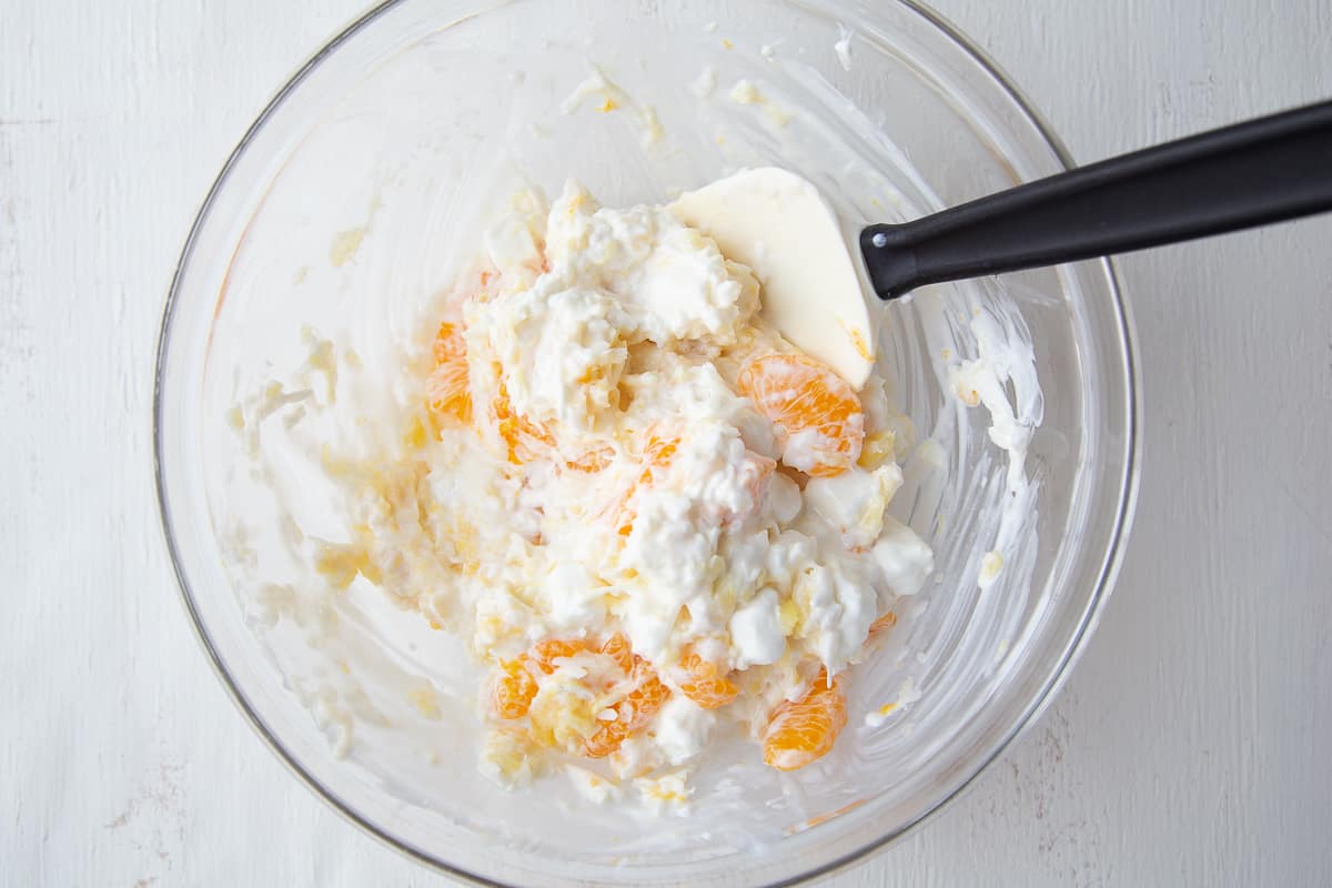 5 cup salad in a large glass bowl with a spatula.