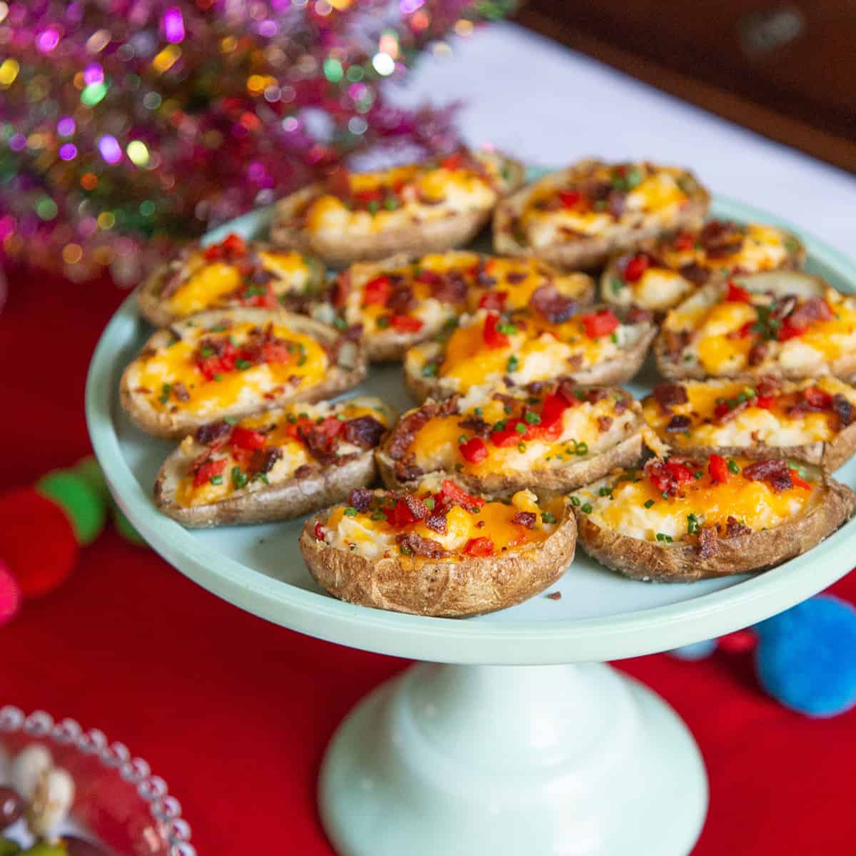 loaded potato skins with pimentos on a green pedestal serving tray
