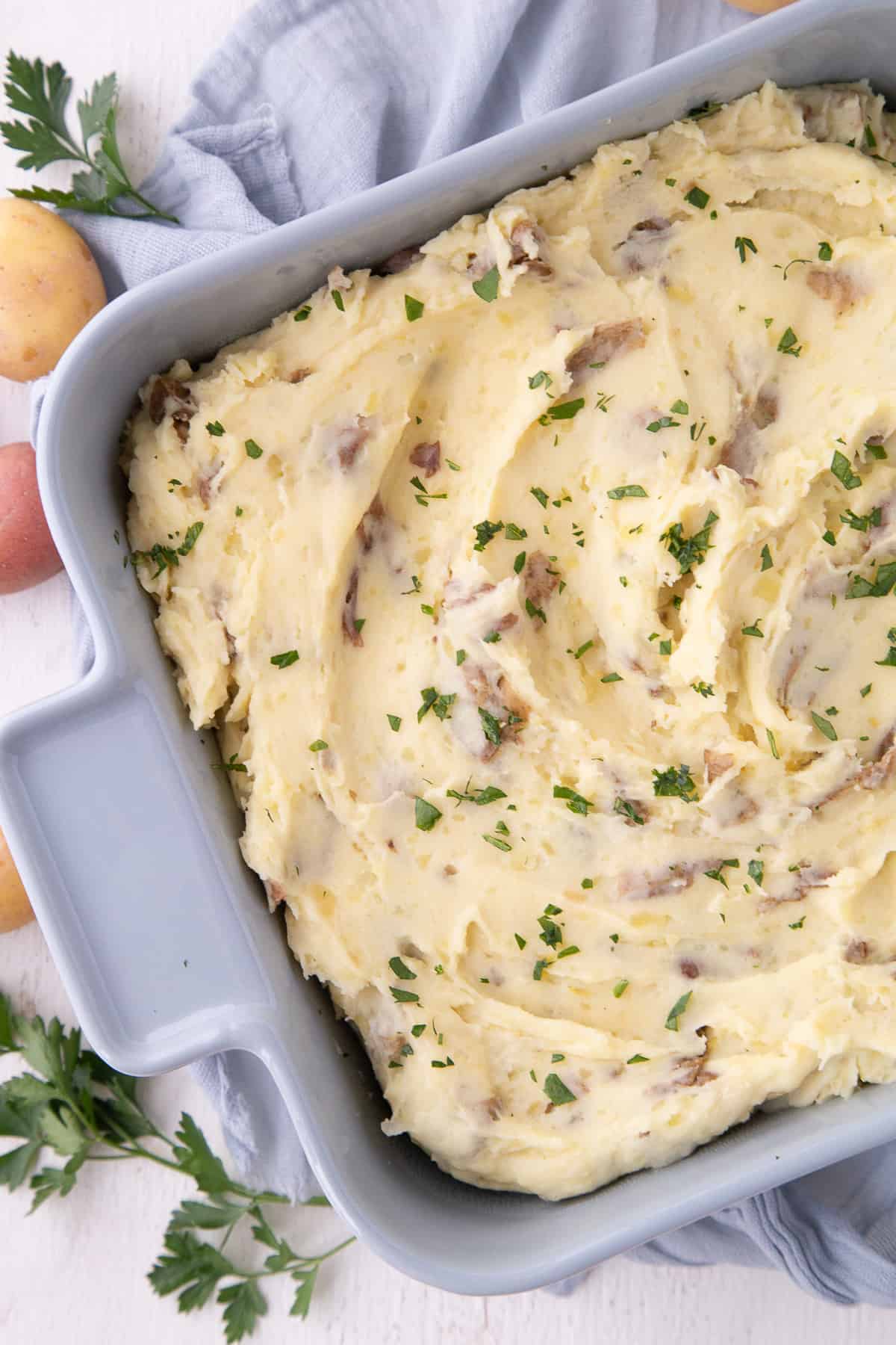 mashed potato casserole in a blue dish on a blue tea towel