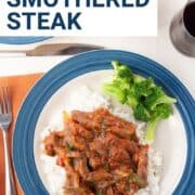 dinner plate with smothered steak, rice, and broccoli.