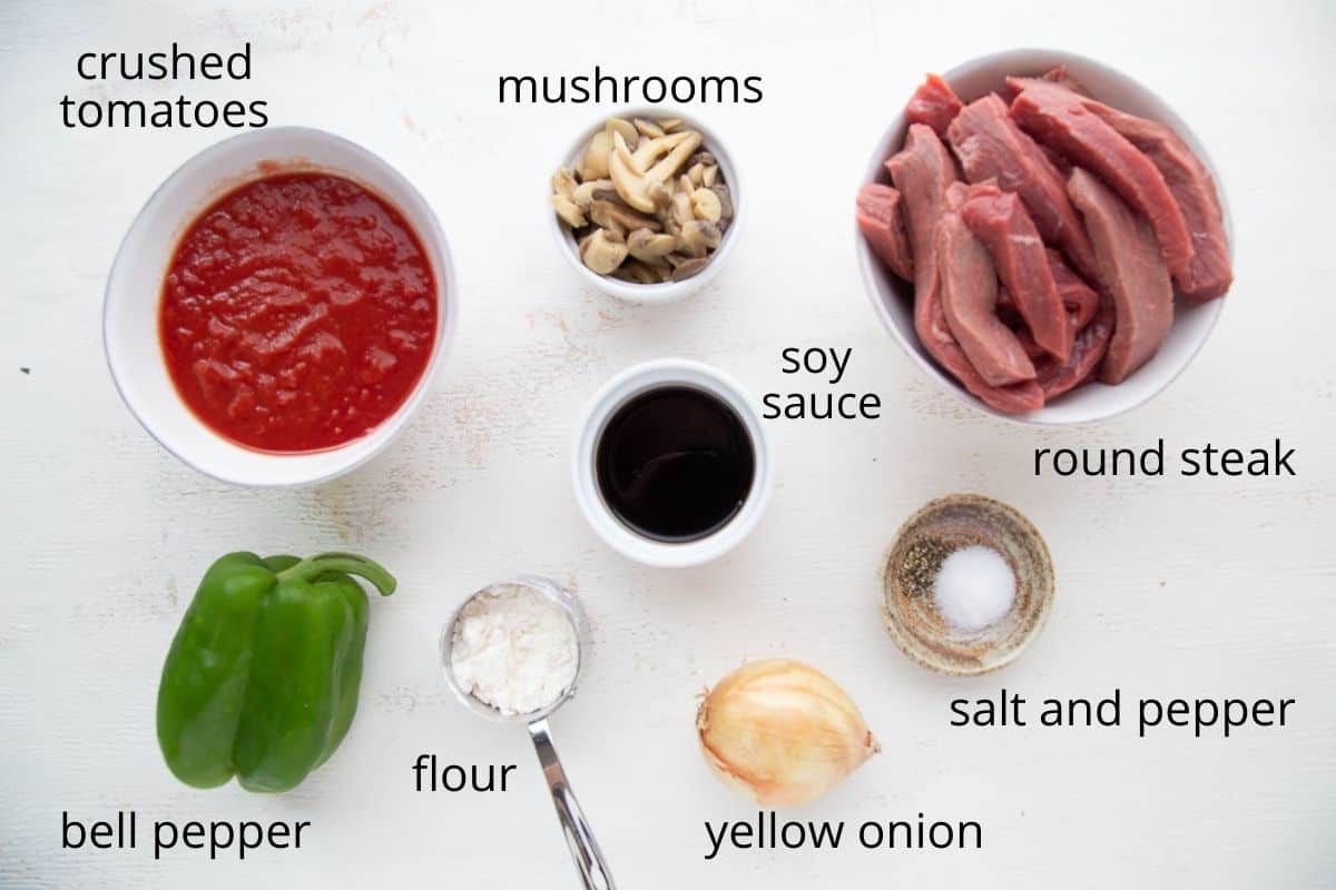 ingredients for smothered steak on a white table.