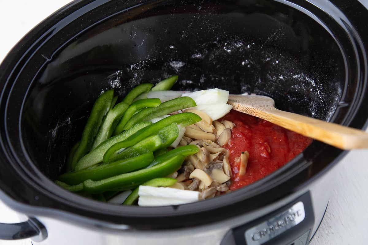 beef, tomatoes, green pepper, and onions in a slow cooker.