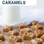 walnut caramels on a wooden board with a glass of milk in the background.