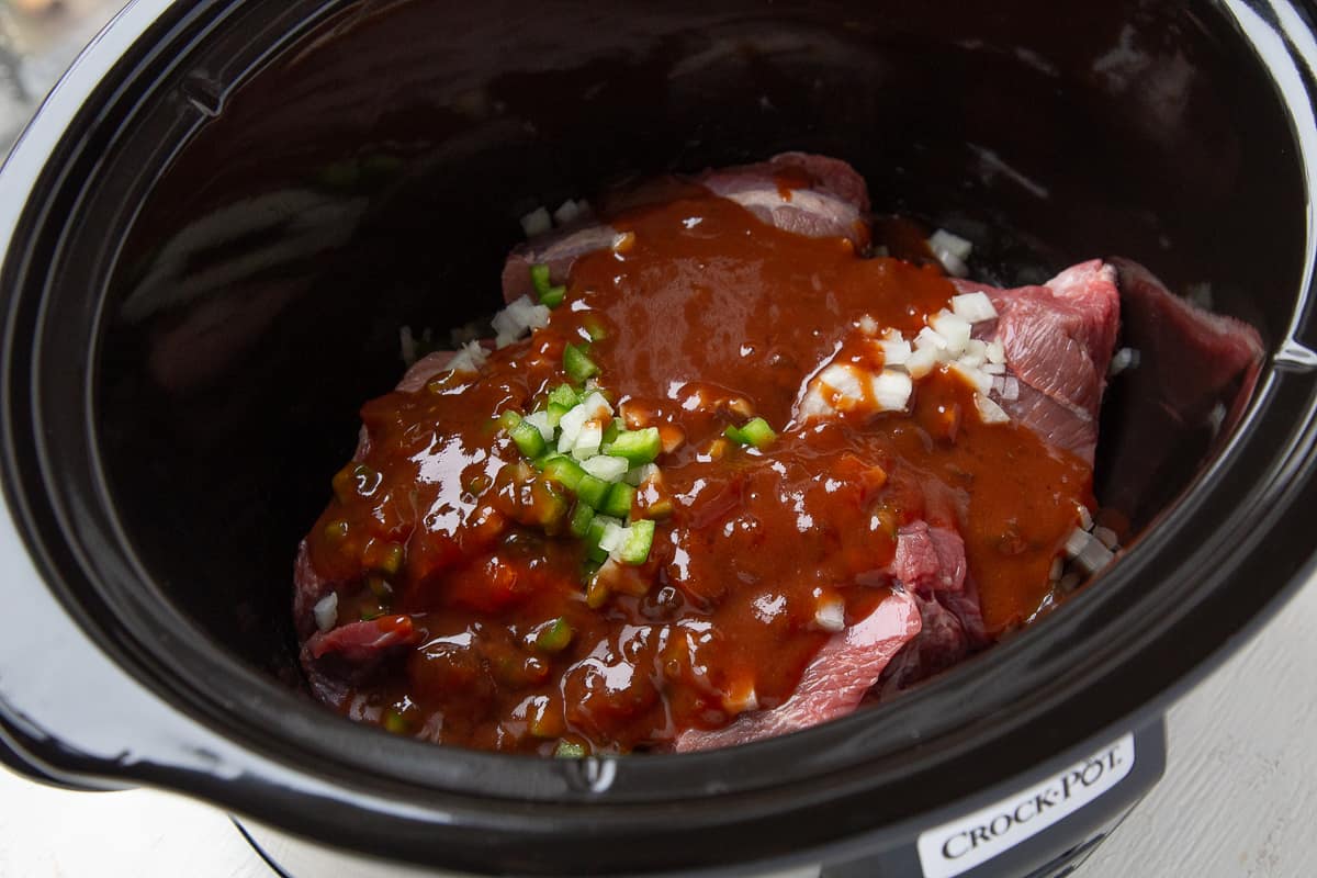 ingredients for beef bbq in a black slow cooker.