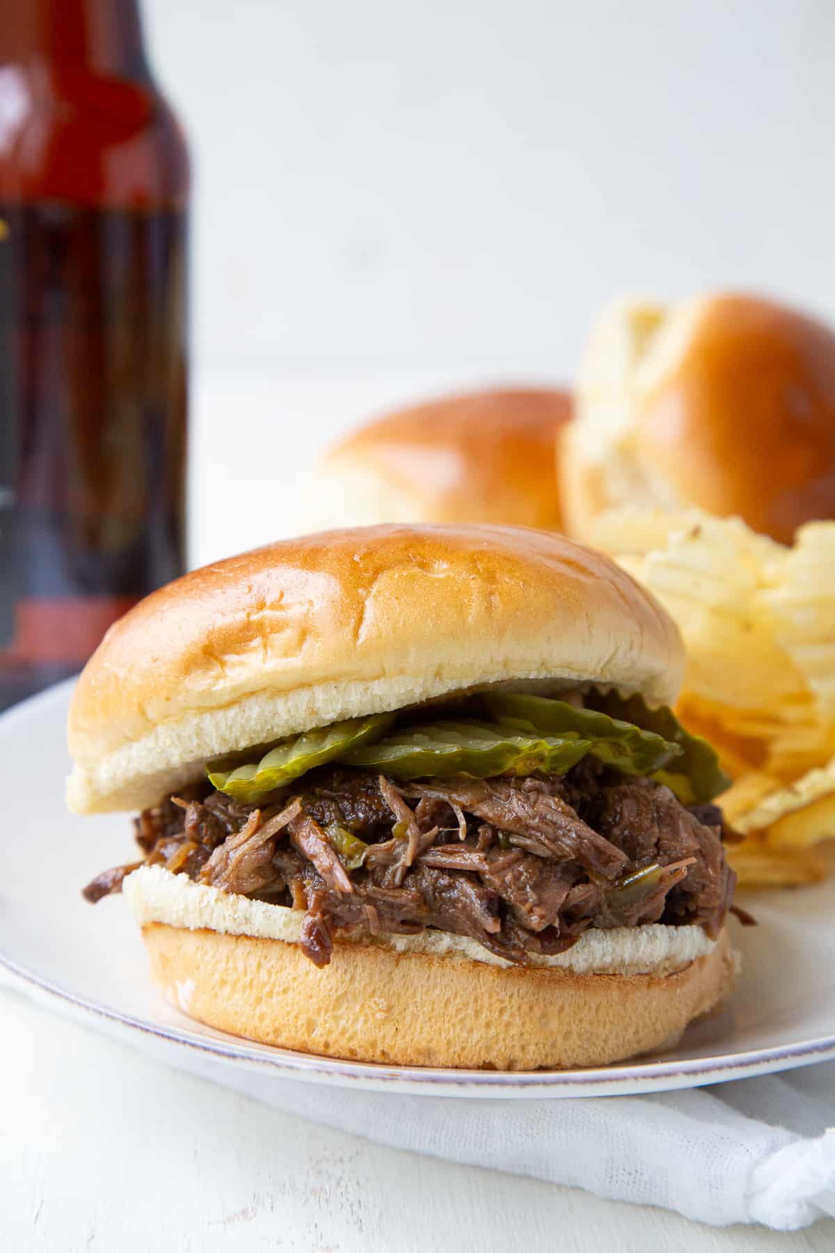slow cooker beef bbq sandwich on a white plate.