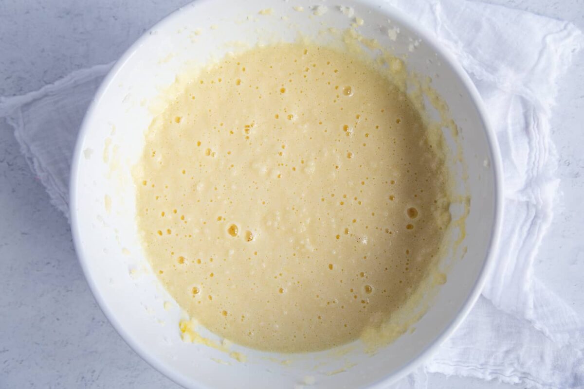 butter, sugar, and eggs beaten into a wet batter, in a white bowl.