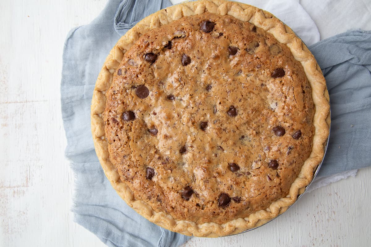 whole cooked cookie pie on a blue and white tea towel.