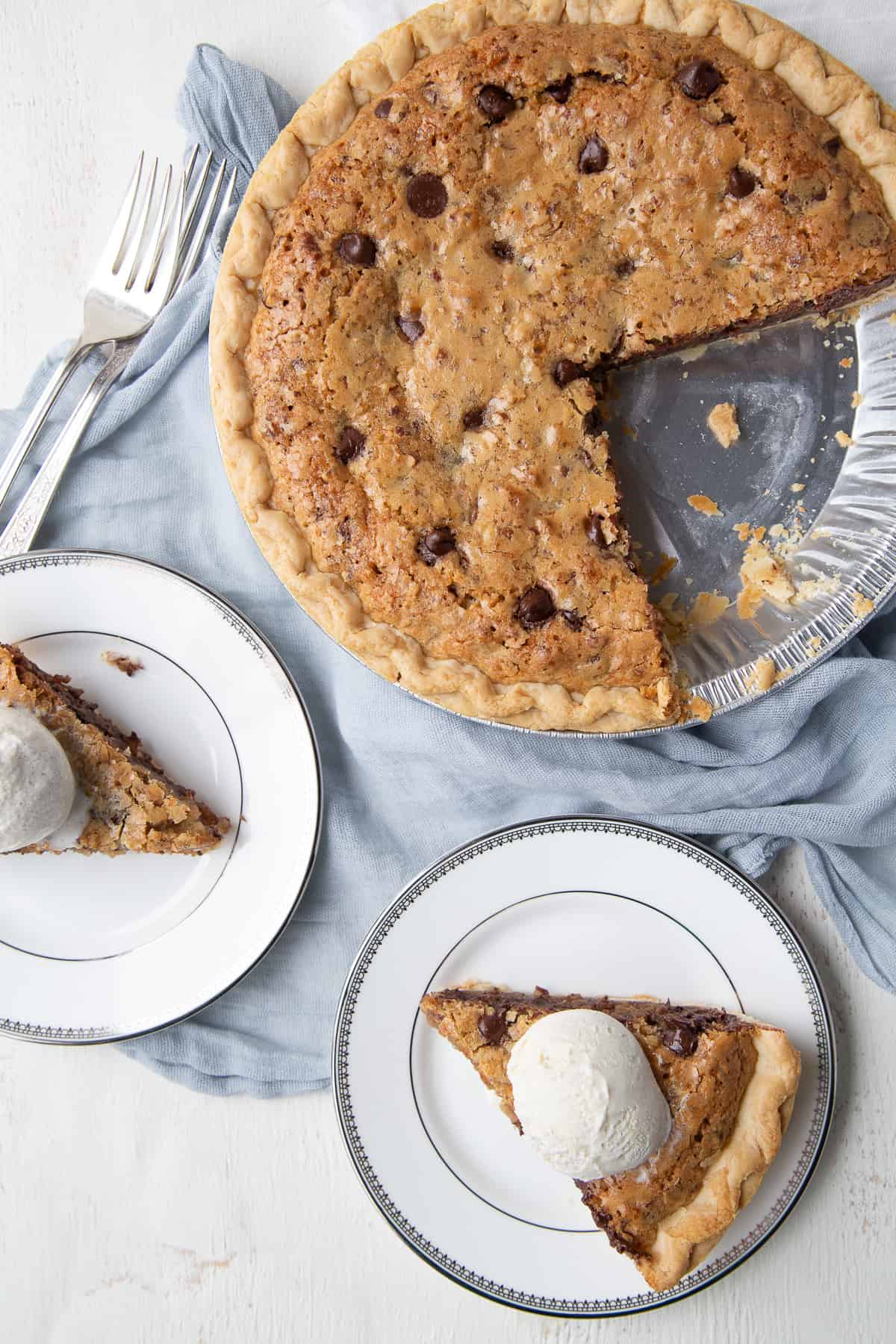 cookie pie with slices taken out on white plates.