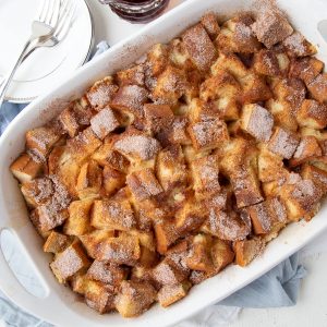 french toast casserole in a white casserole dish.