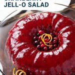 ring of cranberry jello salad on a glass cake stand.