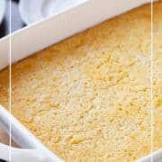 creamed corn casserole in a white casserole dish.