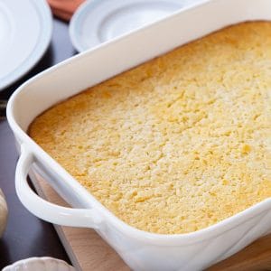 corn casserole in a white casserole dish.