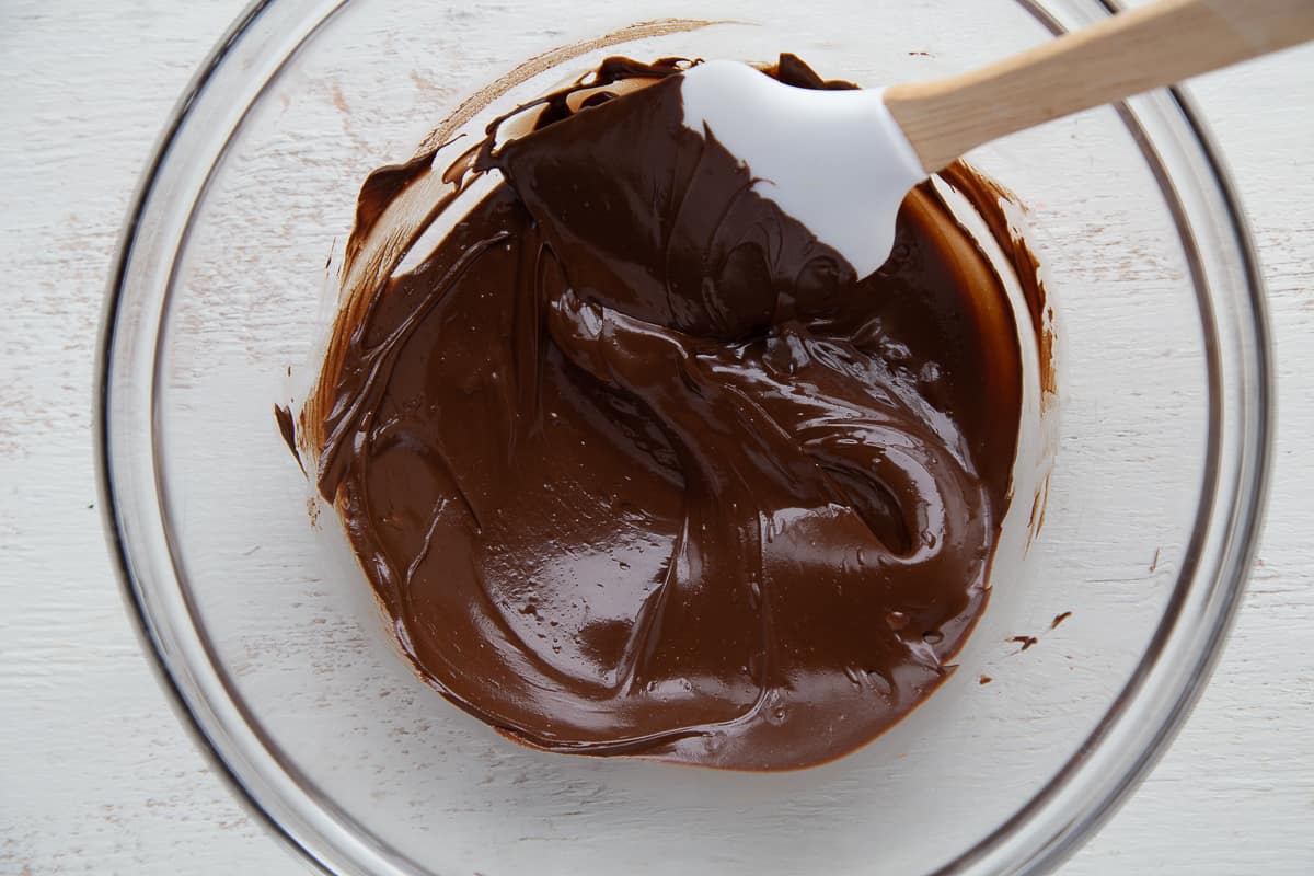 melted chocolate in a glass bowl with a spatula.