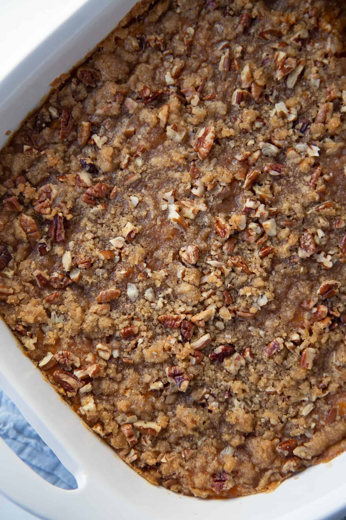 old fashioned sweet potato casserole topped with pecan topping in a white casserole dish.