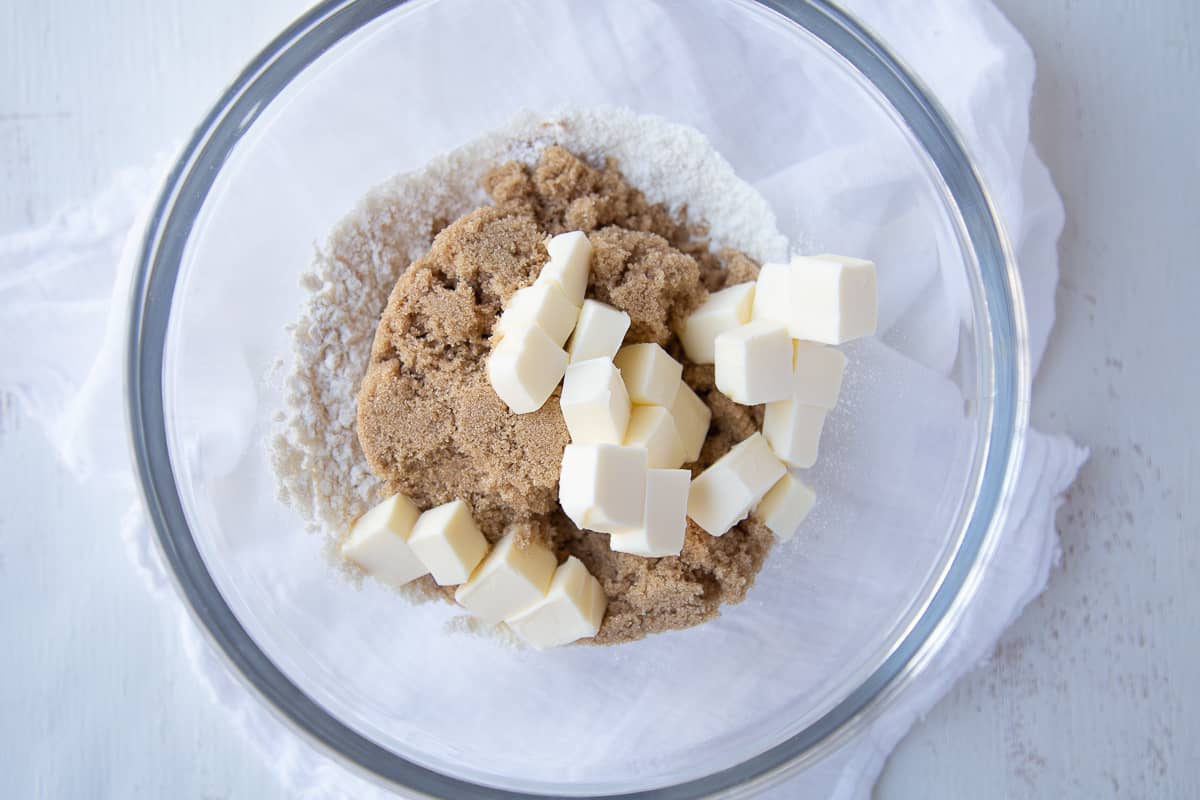 brown sugar, flour, and butter cubes in a glass bowl.
