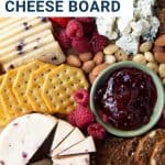 cheese, crackers, and jam on a wooden board.