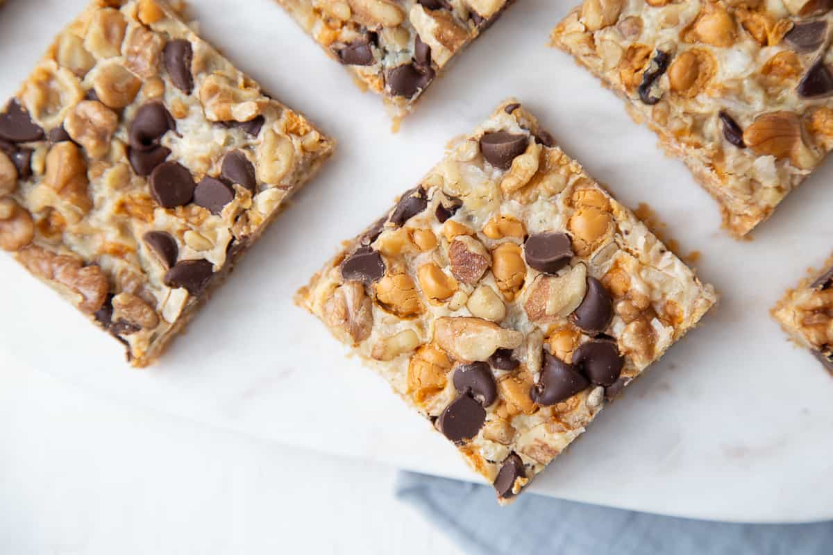 7 layer bars arranged on a white marble tray with a blue towel underneath.