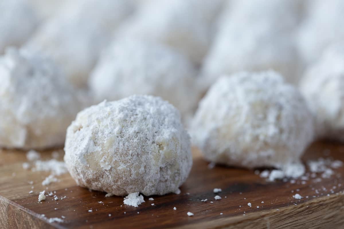 snowball cookies on a wooden board.