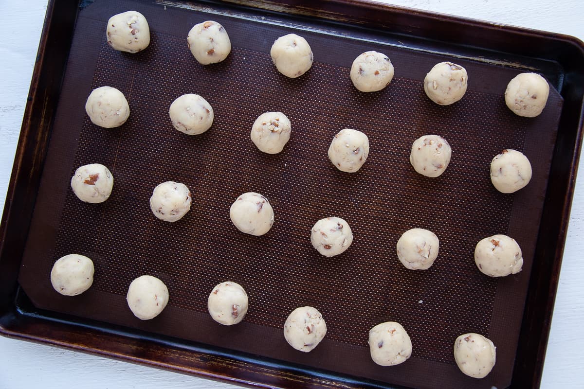 unbaked snowballs on a baking sheet.