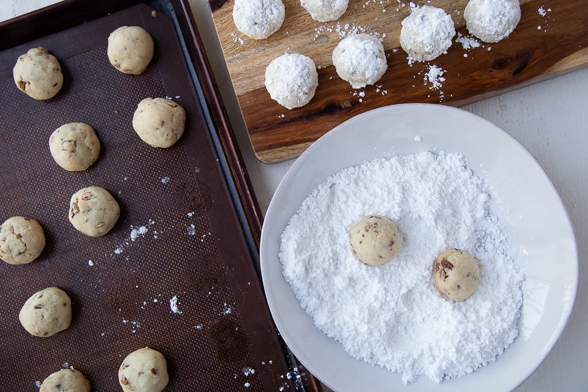 rolling snowballs in a bowl of powdered sugar.