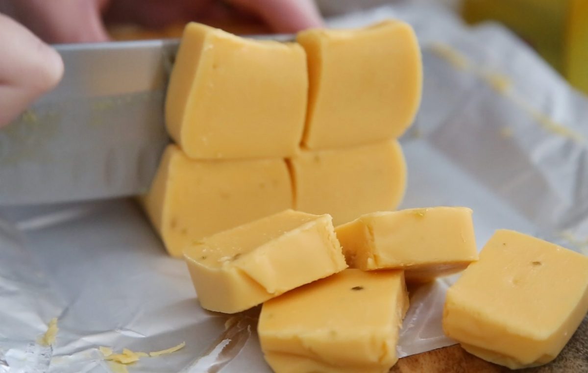 knife cutting velveeta cheese into cubes.