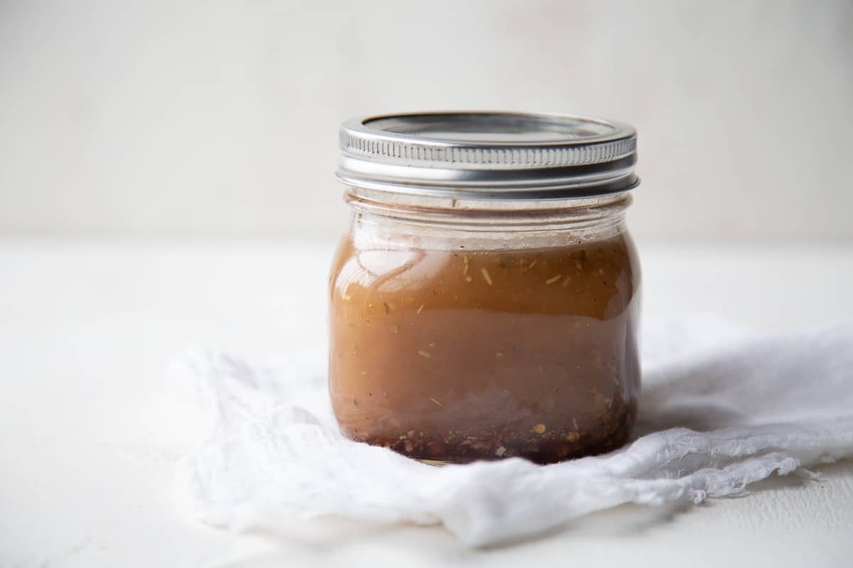 jar of Italian vinaigrette sitting on a white tea towel.