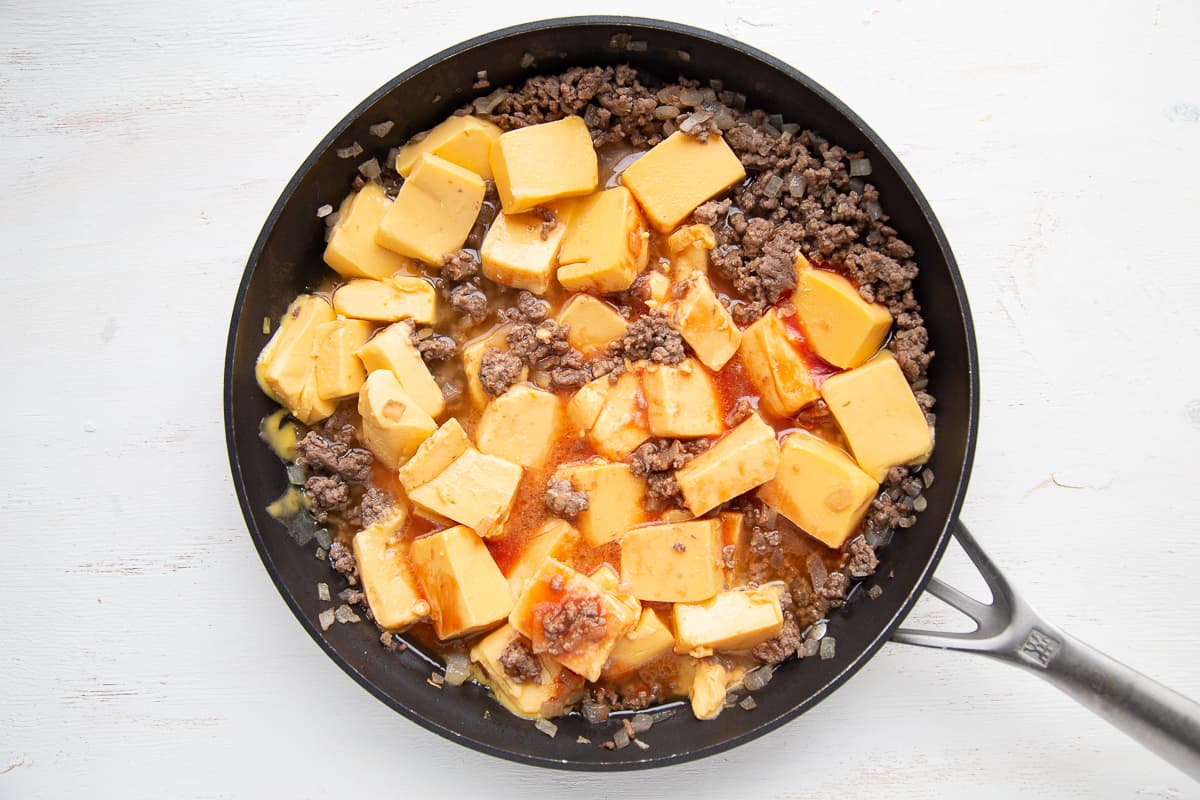 ground beef, onion, and cubed velveeta in a large skillet.