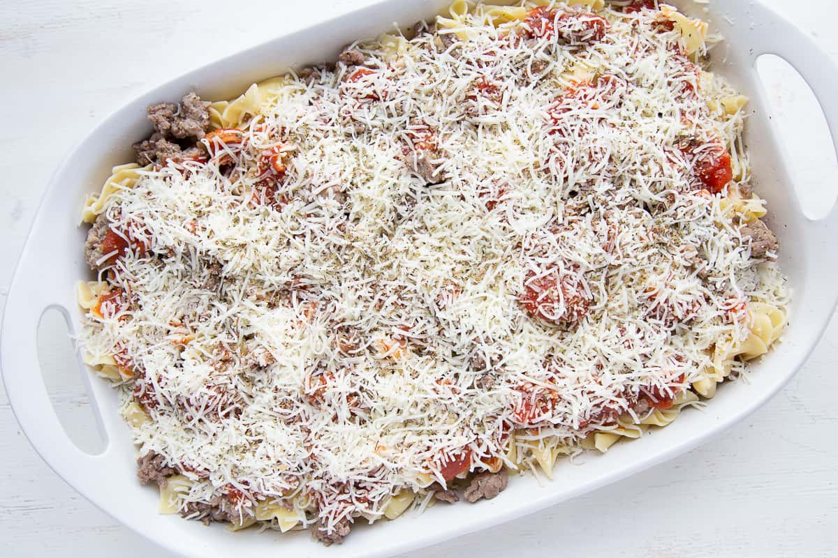 uncooked pizza casserole in a white casserole dish.