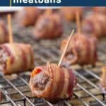 bacon wrapped meatballs with toothpicks sitting on a wire rack.