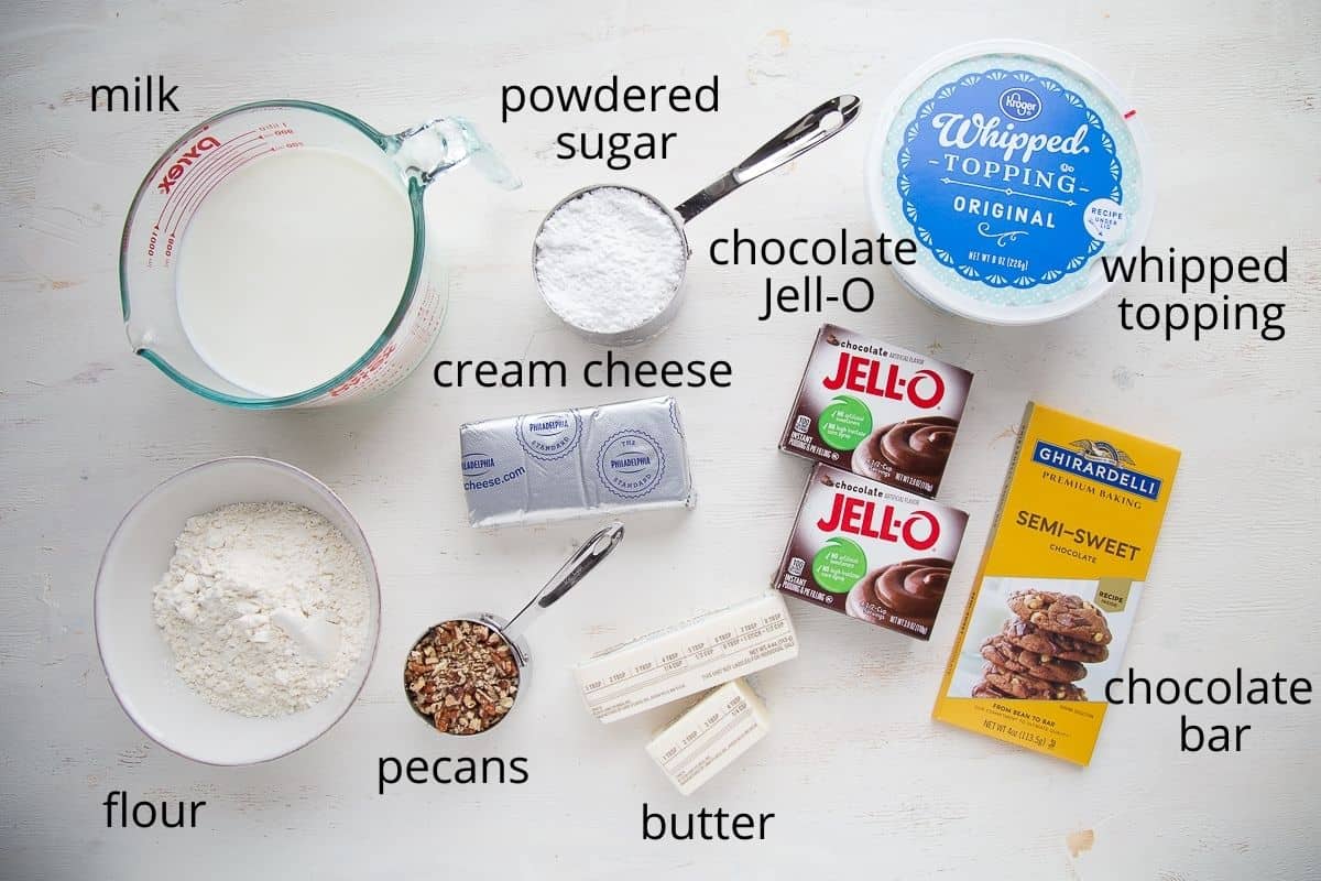 chocolate pudding, whipped topping, milk, and other ingredients on a white table.