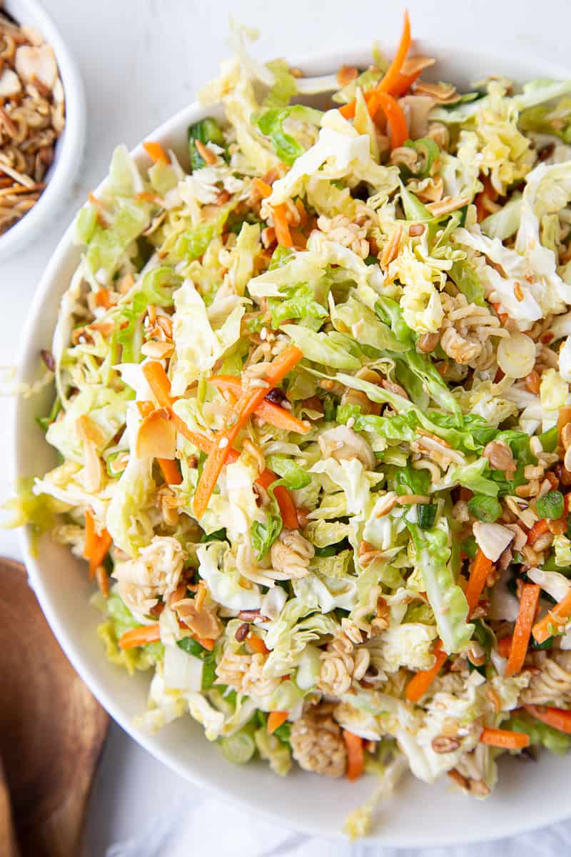 asian cabbage salad with ramen and carrots in a white bowl.