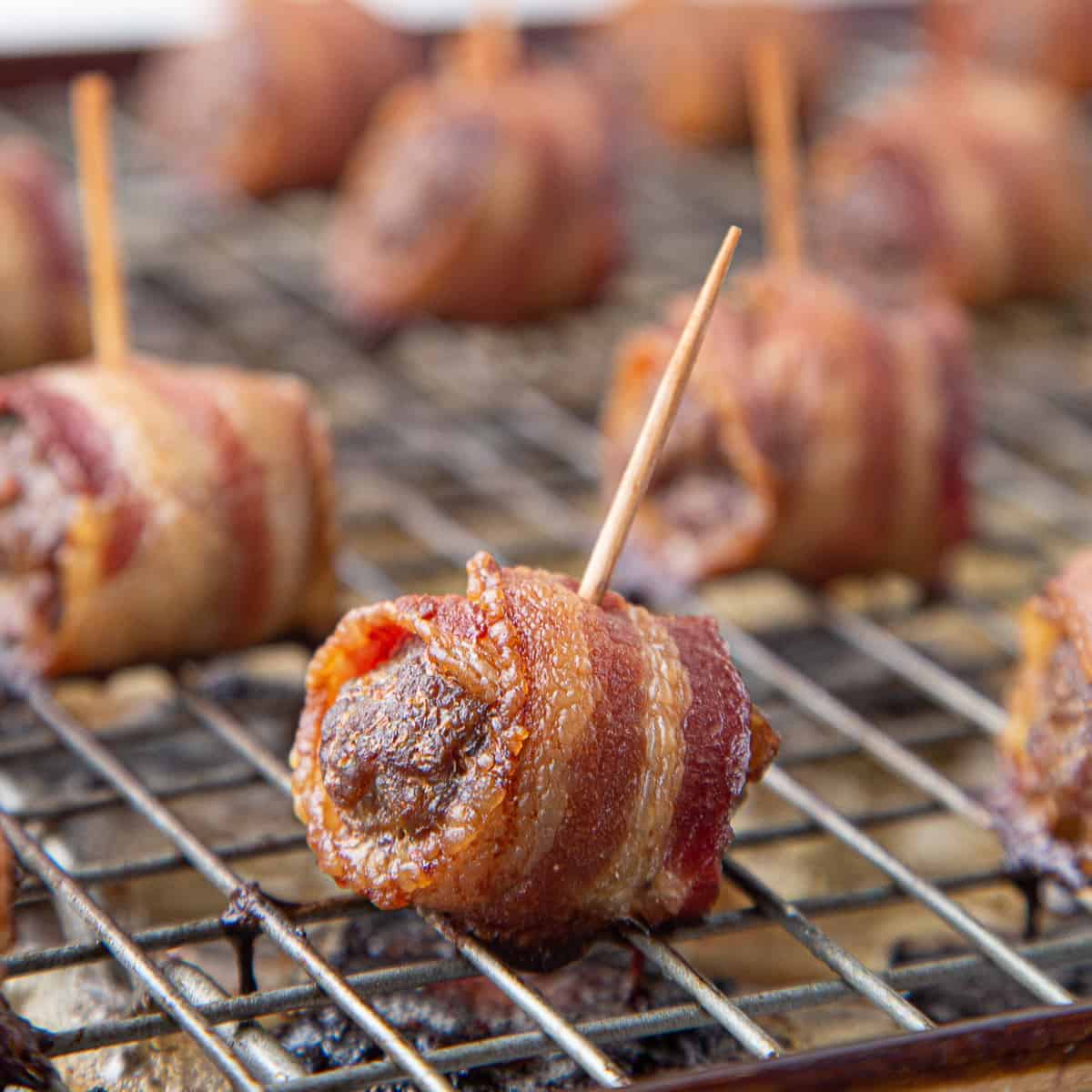 bacon wrapped meatballs on a wire rack.