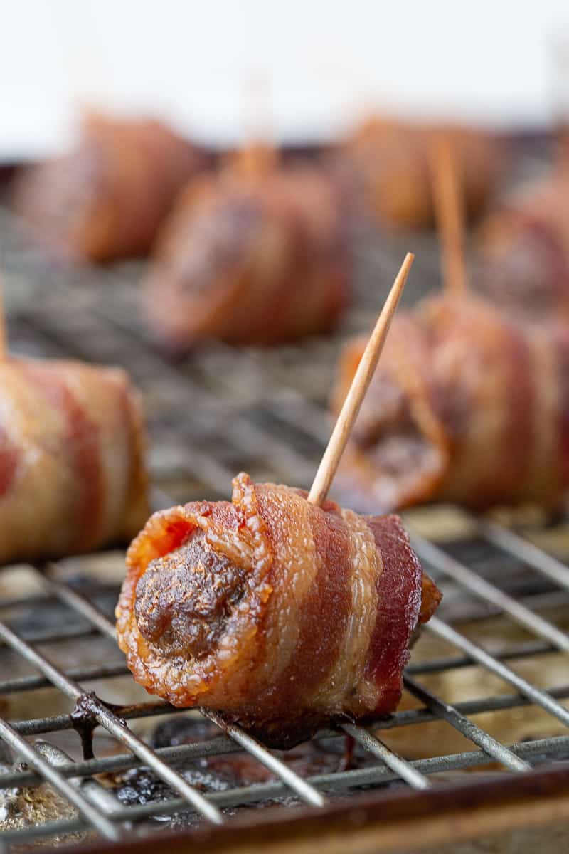 bacon wrapped meatballs on a wire rack.