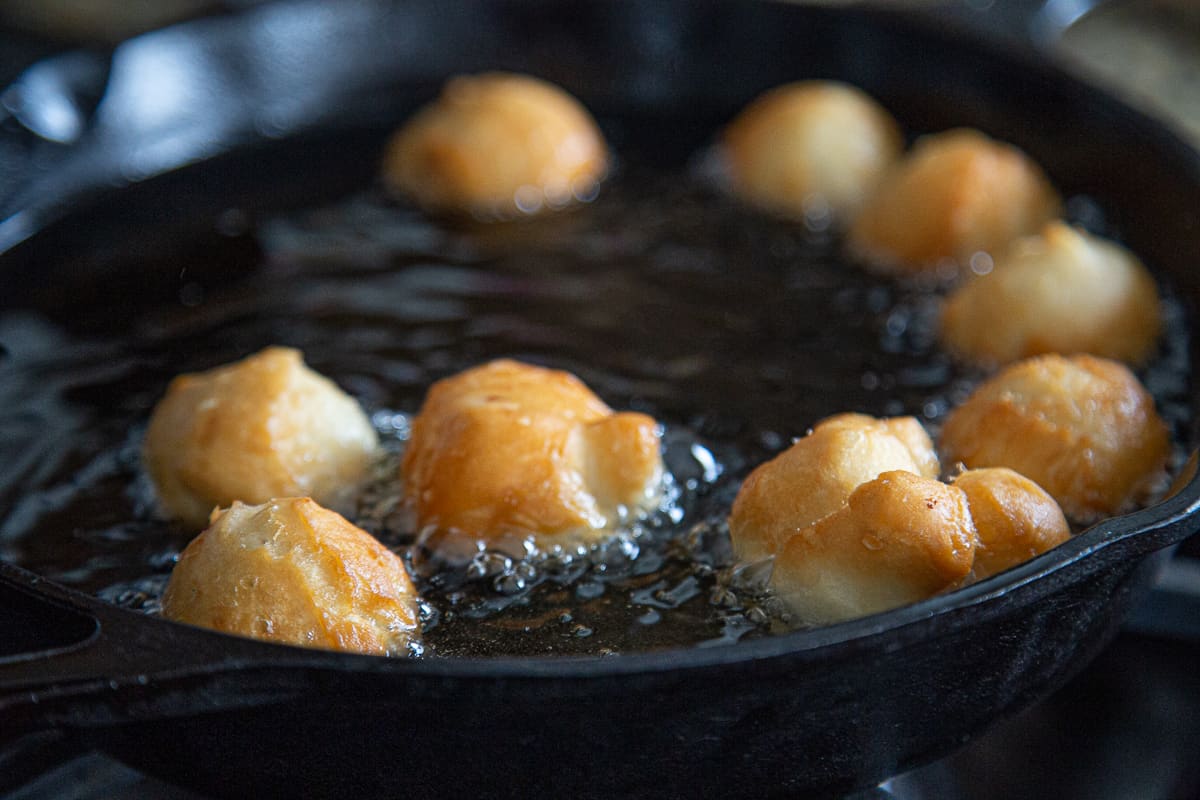 donut holes frying in hot oil.
