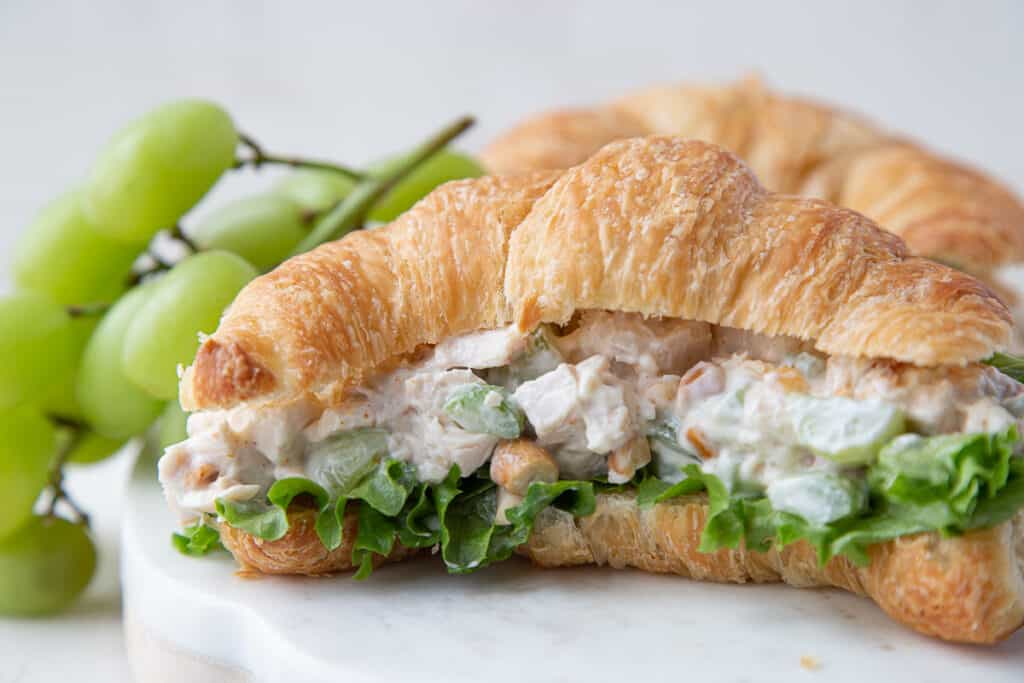 chicken salad on a croissant with green grapes.