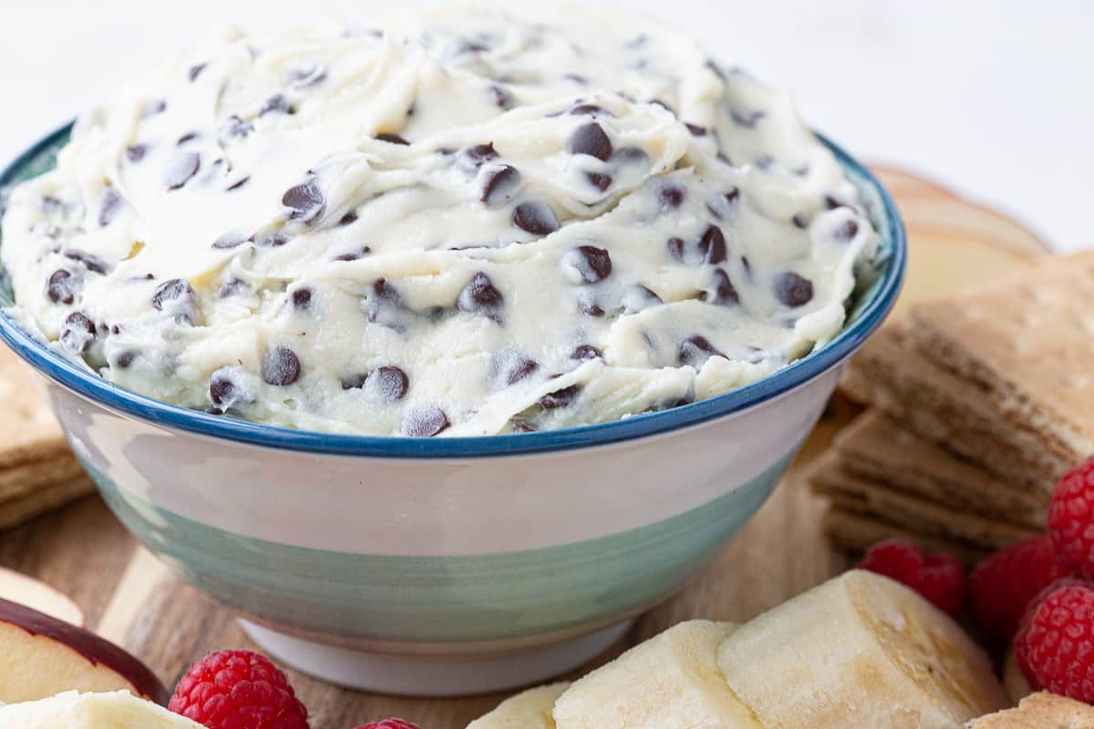 green and blue striped bowl filled with chocolate chip dip.