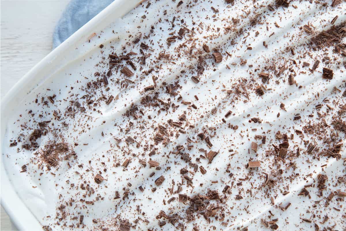 white pan filled with chocolate delight and topped with chocolate shavings.