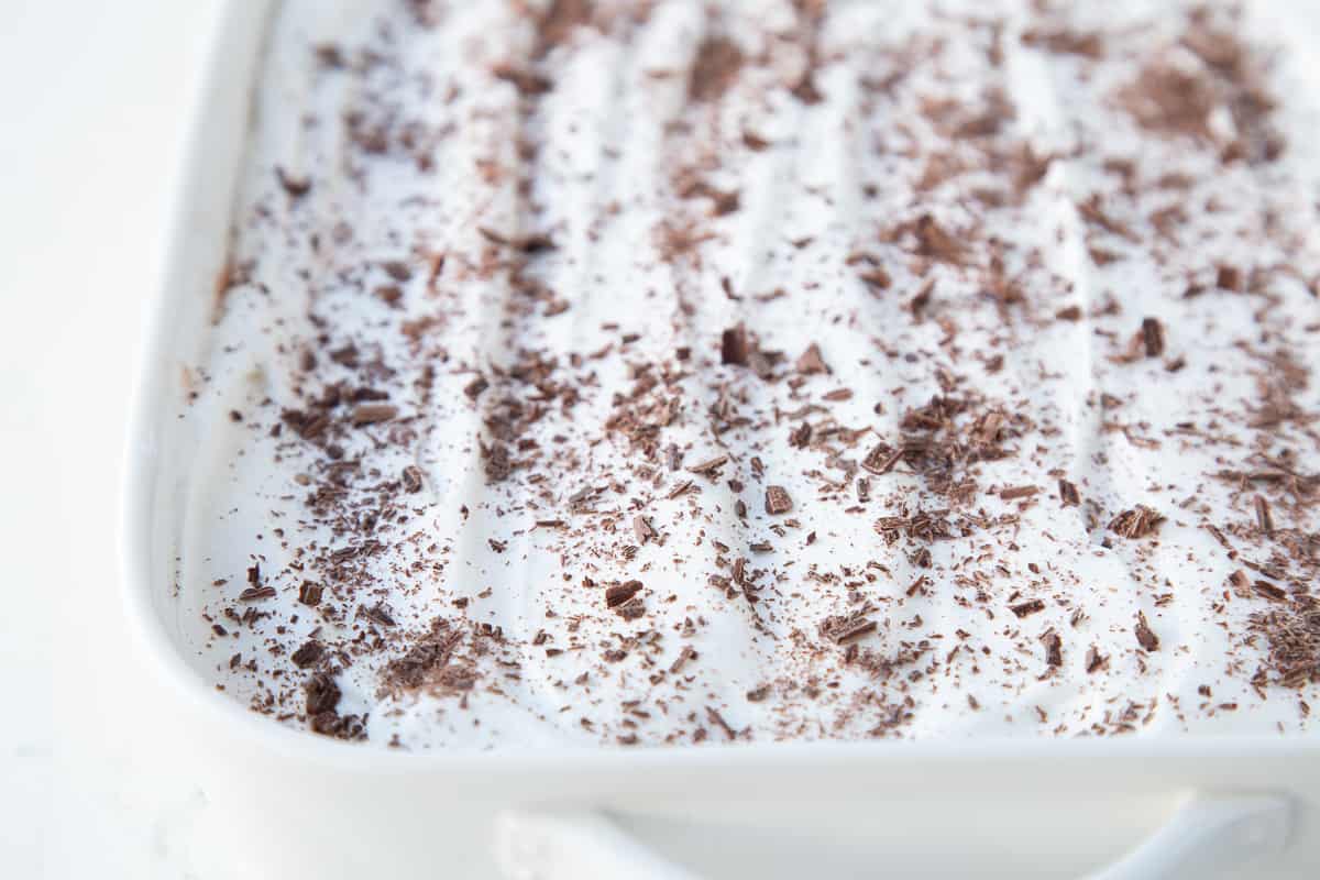 chocolate delight dessert in a white dish with handles, topped with chocolate shavings.
