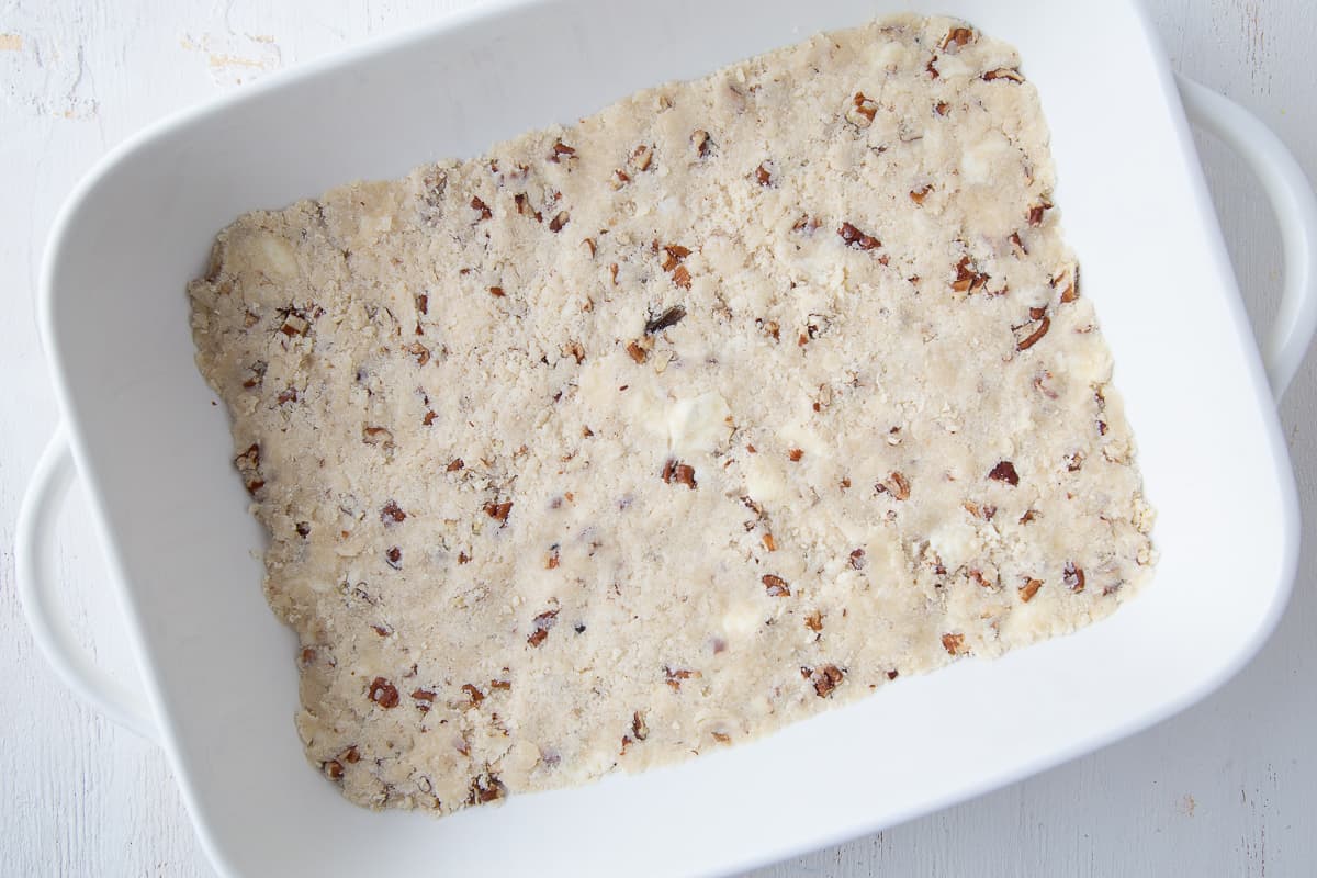 pecan shortbread crust in a white casserole dish.