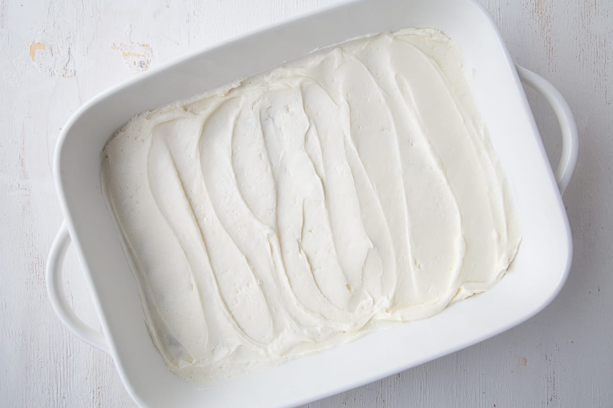cream cheese layer in a white casserole dish.