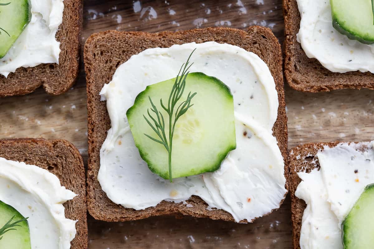 single mini cucumber open faced sandwich topped with a dill sprig.