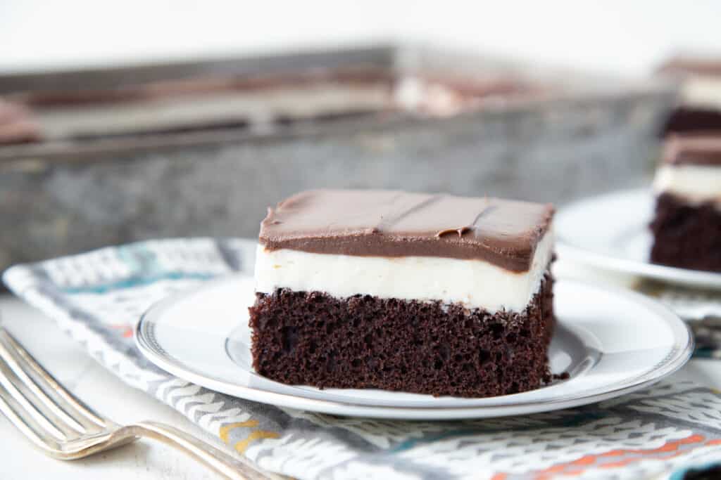 slice of ding dong cake on a white plate with a colorful napkin underneath and a fork nearby.