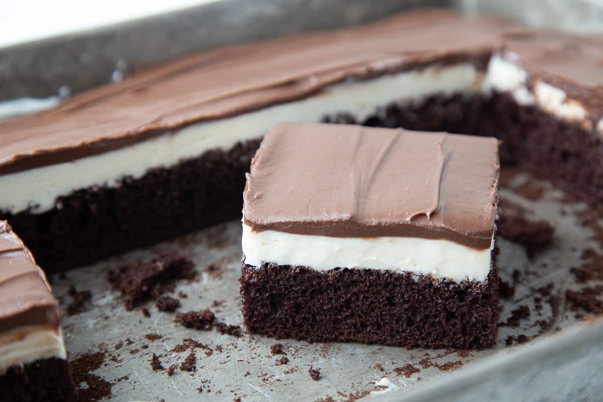 slice of ding dong cake in a cake pan, surrounded by more cake.