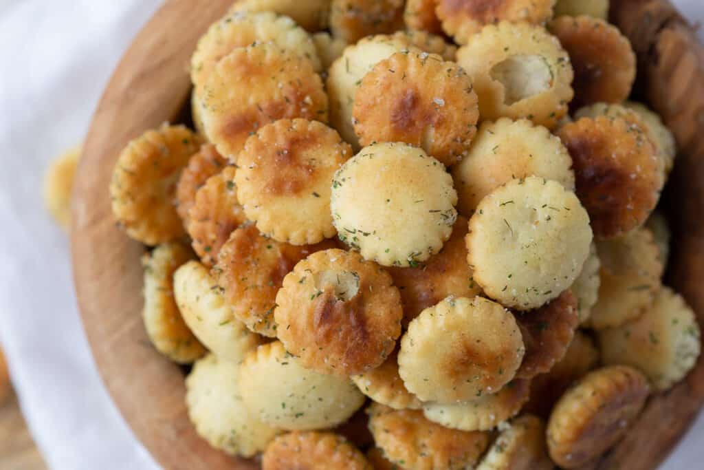 seasoned ranch oyster crackers in a wooden bowl on a white towel.